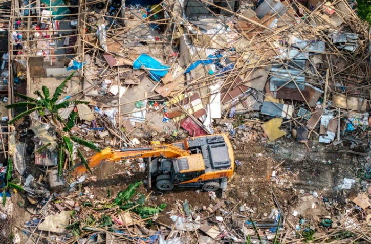Une pelleteuse entame la démolition des bidonvilles abritant des milliers de personnes le long des berges de la capitale népalaise Katmandou, le 25 avril 2026