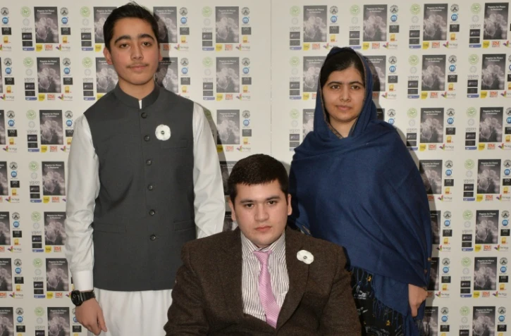 La Prix Nobel de la Paix Malala Yousafzai pose avec deux victimes de l'attentat de l'école publique de l'armée de Peshawar, Ahmad Nawaz (g) et Muhammad Ibrahim Khan (c) à Birmingham, le 15 décembre 2015