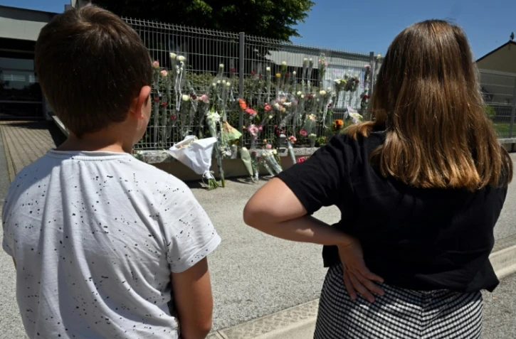 Des élèves se recueillent devant les fleurs déposées au collège Françoise Dolto à Nogent, au lendemain du meurtre d'une surveillante, le 11 juin 2025 en Haute-Marne