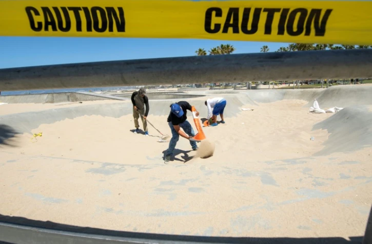 Des skateurs nettoient le skate park de Venice Beach (Etats-Unis), auparavant empli de sable pour éviter tout rassemblement, le 13 mai 2020