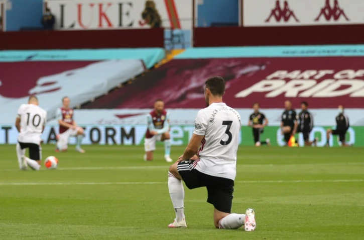 Les joueurs de Sheffield United et Aston Villa mettent un genou à terre, en soutien au mouvement Black Lives Matter, le 17 juin 2020 à Birmingham