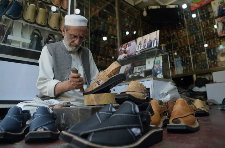 Le chausseur Chacha Noor Din fabrique des "chappals", sandale traditionnelle au Pakistan, le 1er avril Ă Peshawar