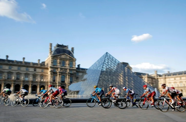 Le peloton passant devant la pyramide du Louvres à Paris lors de la dernière étape du Tour de France 2019  entre Rambouillet et les Champs Elysées, le 28 juillet.