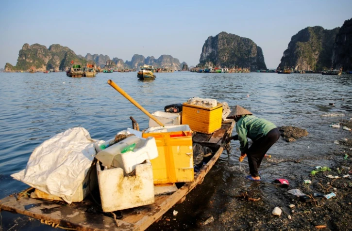 Un homme ramasse des déchets dans la baie d'Ha Long, au Vietnam, le 17 mai 2023