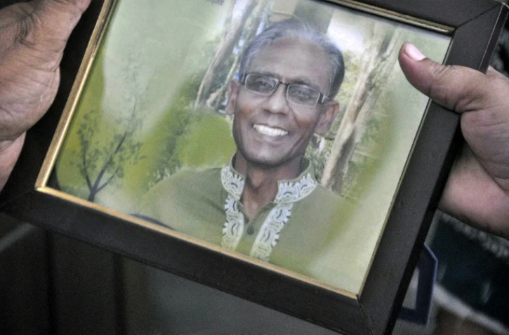 Un homme montre le portrait du professeur Rezaul Karim Siddique, à Rajshahi, le 23 avril 2016