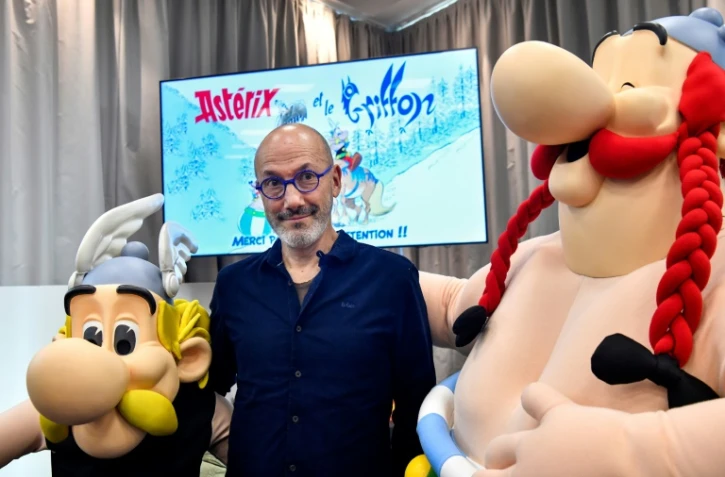 Le scénariste Jean-Yves Ferri pose entre les effigies d'Astérix et Obélix lors de la présentation de l'album "Astérix et le Griffon" à Vanves, près de Paris, le 11 octobre 2021