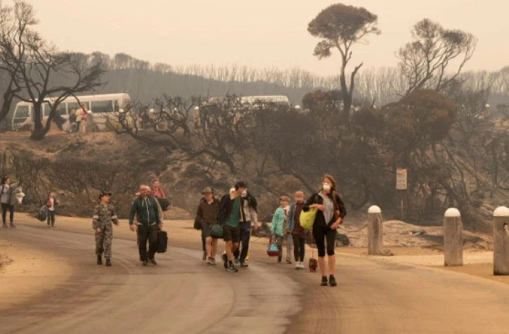 Des habitants marchent vers une plage avant d'être évacués de Mallacoota, en Australie, le 3 janvier 2020