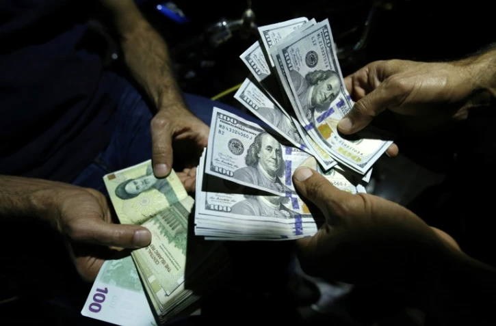 Le rial, la monnaie nationale iranienne, a chuté en raison des sanctions américaines. Images d'un homme échangeant ses rials contre des dollars le 8 août à Téhéran