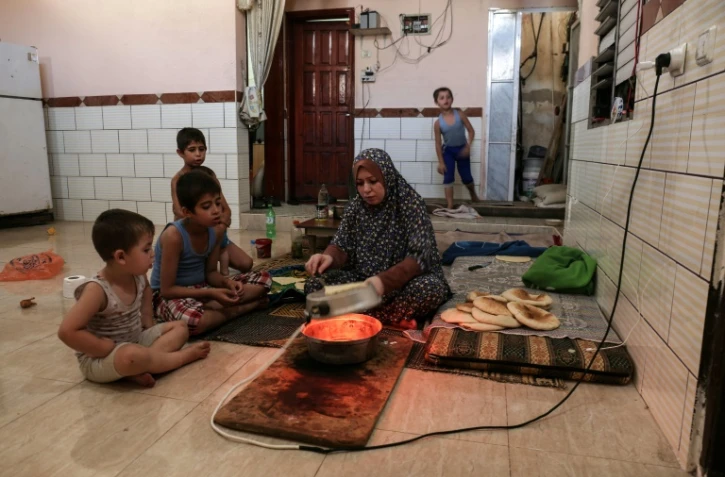 Une femme palestinienne fait du pain profitant de quelques heures de courant pare jour à Rafah, dans la bande de Gaza, le 3 août 2017