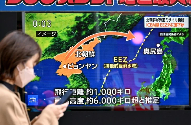 Un piéton passe, le 18 décembre 2023 à Tokyo, devant une télévision diffusant un reportage sur le tir par la Corée du Nord d'un missile balistique de longue portée potentiellement capable de frapper les Etats-Unis
