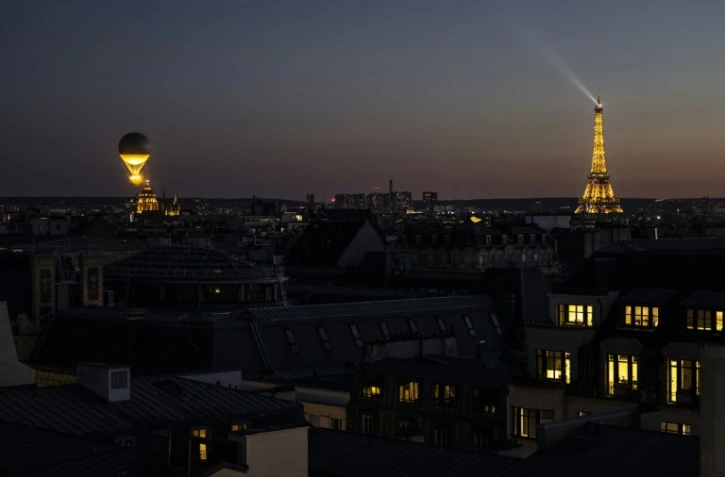 La vasque des Jeux Olympiques de Paris 2024 décolle du Jardin des Tuileries avec la Tour Eiffel en arrière-plan au coucher du soleil à Paris, le 5 août 2024