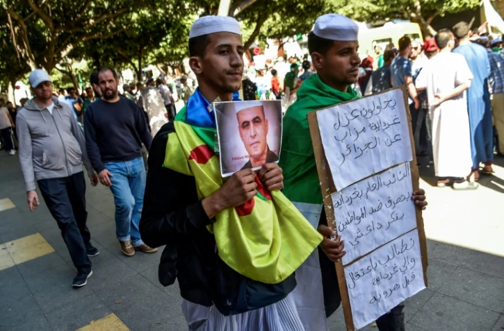 Des Algériens manifestent, brandissant le drapeau amazigh et un portrait du militant des droits humains, Kamel Eddine Fekhar, à Alger le 31 mai 2019