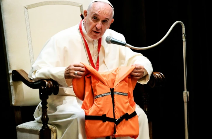 Le pape François montre lors d'une réunion avec des jeunes, le 28 mai 2016 au Vatican, le gilet de sauvetage d'un jeune qui s'est noyé en Méditerranée en essayant de rejoindre l'Europe