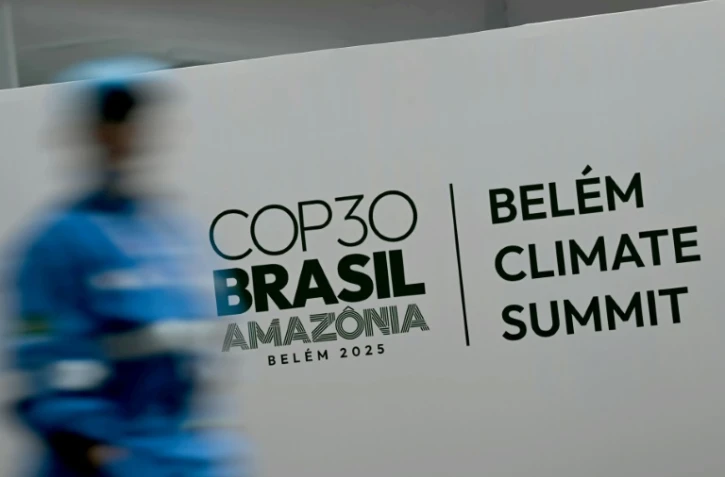 Une personne passe devant une affiche de la COP 30, à Belem au Brésil, le 5 novembre 2025