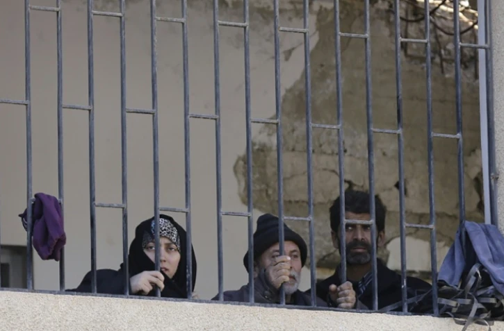 Des civils syriens rassemblés dans une école à Adra, une localité sous contrôle du régime après leur fuite des secteurs rebelles de la Ghouta orientale devant la progression des forces prorégime, le 16 mars 2018