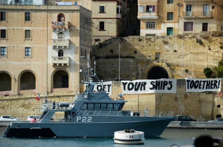 Un bateau des gardes-côtes maltais patrouillent dans la baie de Birgu à Malte, devant des banderoles où l'on peut lire "Get your ships together", le 23 septembre 2019