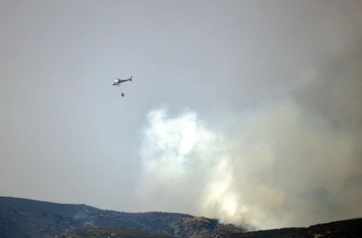 Un hélicoptère intervient pour éteindre un incendie de forêt à San Ciprian de Sanabria, dans le nord-ouest de l'Espagne, le 21 août 2025
