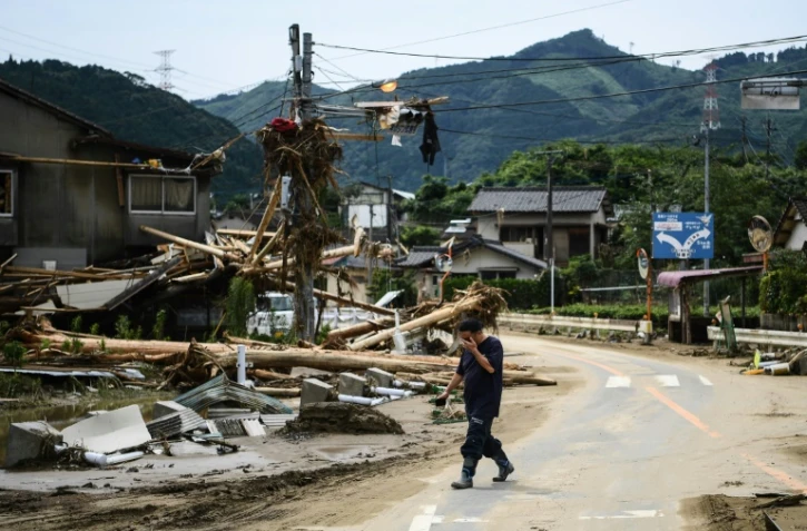 Un homme passe devant des décombres après des pluies torrentielles et des inondations dans le village de Kuma au Japon, le 8 juillet 2020