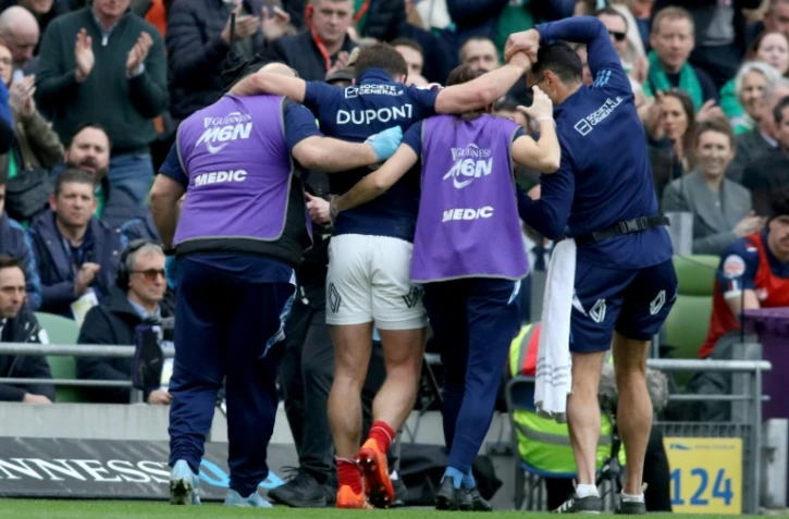 Le demi de mêlé des Bleus sort, porté par les soigneurs, après sa blessure à un genou durant la rencontre du Tournoi des six nations contre l'Irlande, le 8 mars 2025 à Dublin
