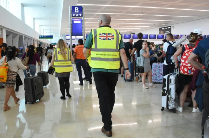 Des responsables britanniques apportent leur aide à des clients de Thomas Cook à l'aéroport de Cancun, au Mexique, le 23 septembre 2019
