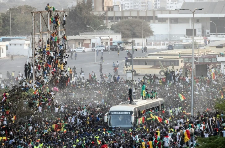 Des supporteurs accueillent les joueurs de football sénégalais, vainqueurs de la CAN, le 7 février 2022 à Dakar