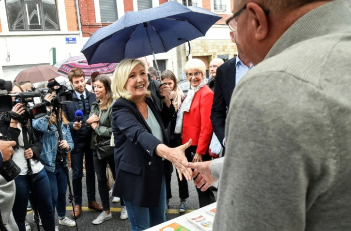 La président du RN Marine Le Pen, présidente du Rassemblement National (RN), salue les gens alors qu'elle se rend au marché aux puces local "braderie" le 8 septembre 2019 à Hénin-Beaumont, dans le nord de la France.
