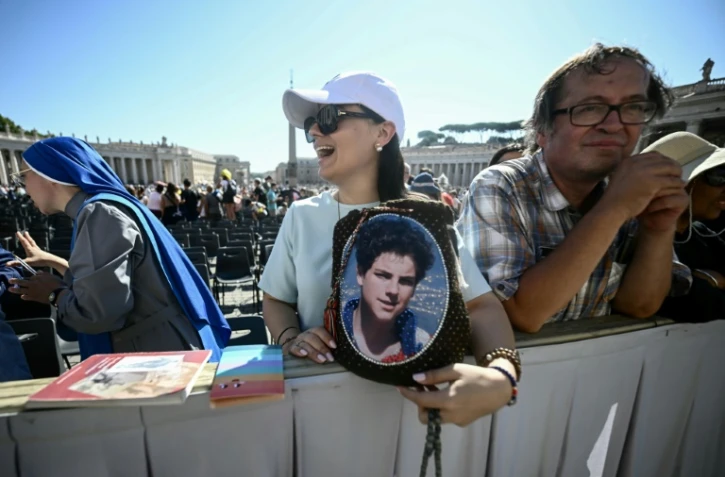 Un fidèle tient un portrait du bienheureux italien Carlo Acutis à la veille de sa canonisation, lors d'une audience jubilaire sur la place Saint-Pierre au Vatican le 6 septembre 2025