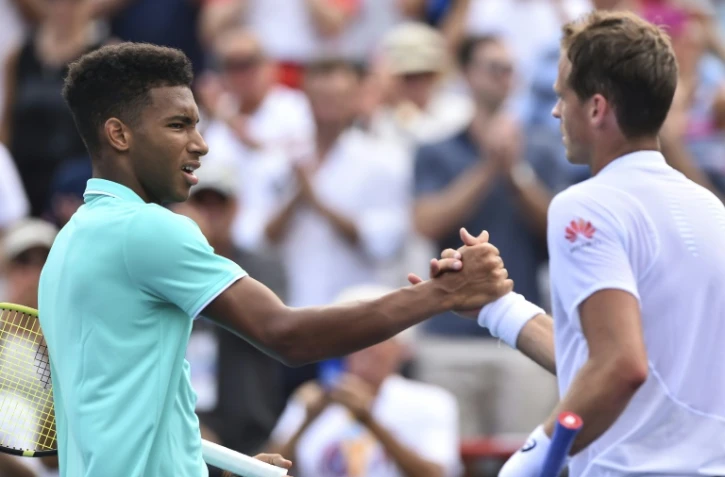 Le Canadien Félix Auger-Aliassime (g) serre la main de son compatriote Vasek Pospisil après l'avoir battu au 1e tour du Masters 1000 de Montréal, le 6 août 2019