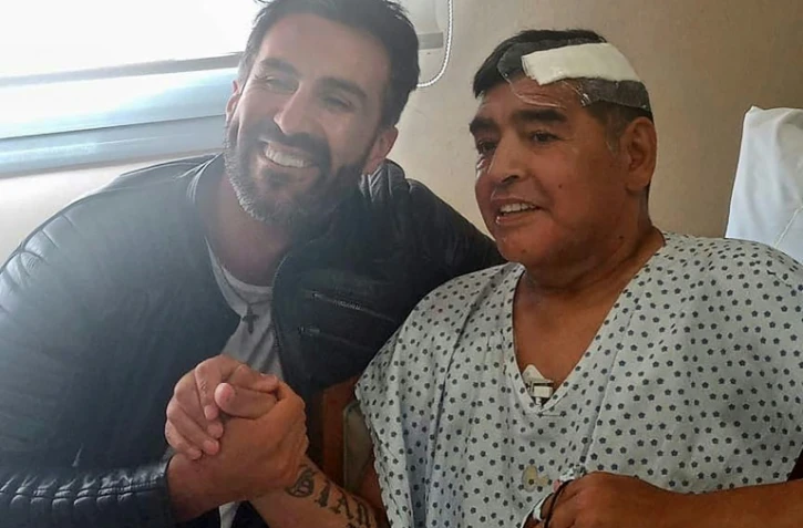 La légende du football Diego Maradona serra la main de son médecin Leopoldo Luque, à Buenos Aires, le 11 novembre 2020