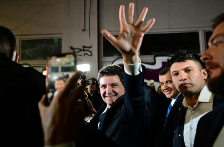 Le maire de Bucarest Nicusor Dan salue ses supporters après sa victoire à la présidentielle roumaine, le 18 mai 2025 à Bucarest