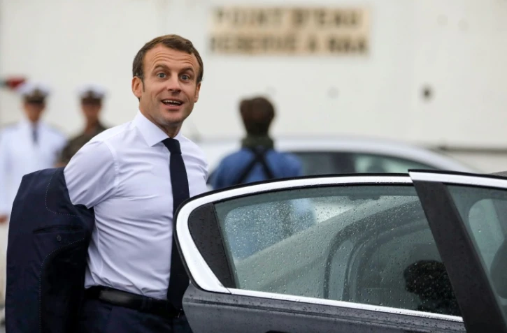 Le président Emmanuel Macron monte dans une voiture après avoir atterri à l'aéroport de Saint-Denis de la Réunion le 23 octobre 2019  à La Réunion, dans le cadre d'un voyage de quatre jours dans l'île française de l'océan Indien.