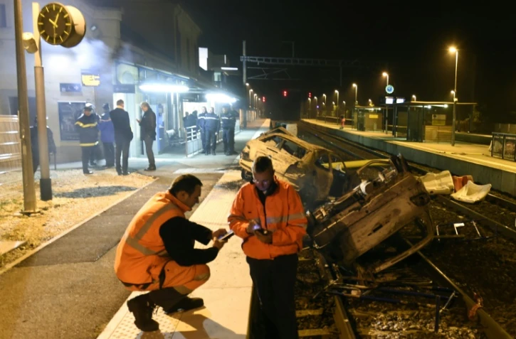 Des agents SNCF et la police près de voitures calcinées sur les voies ferrées devant la gare de Moirans, le 20 octobre 2015