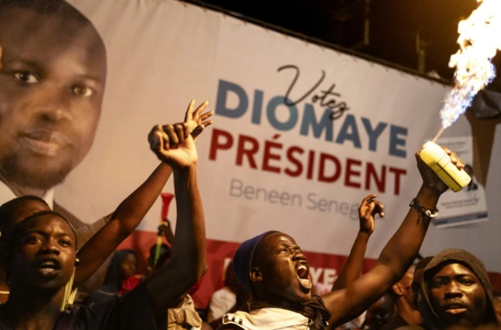 Des partisans du candidat antisystème Bassirou Diomaye Faye célèbrent sa victoire à la présidentielle sénégalaise, à Dakar le 24 mars 2024