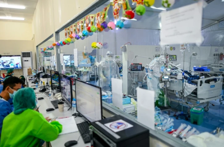 Des médecins s'occupent de patients atteints du Covid-19 dans l'unité de soins intensifs au centre Ayeyarwady, un hôpital de campagne édifié sur un stade de Rangoun, le 1er janvier 2021 en Birmanie