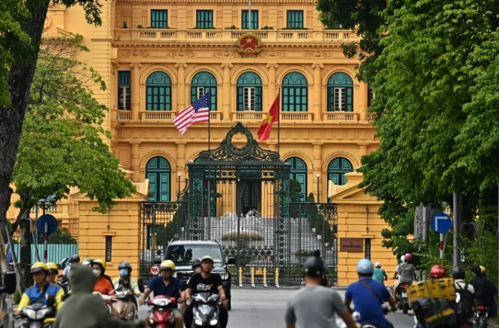 Le drapeau américain flotte au côté du drapeau vietnamien devant le palais présidentiel à Hanoï le 9 septembre 2023, à la veille de l'arrivée du président américain Joe Biden