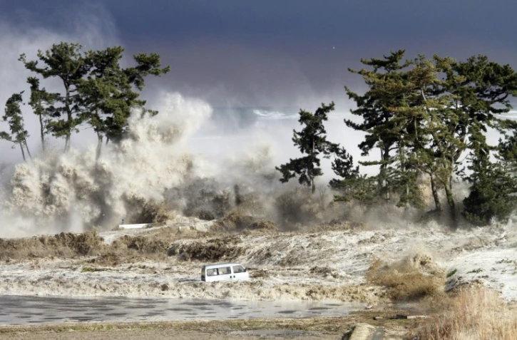 Le tsunami déferle sur Minamisoma, dans le nord-est du Japon, le 11 mars 2021