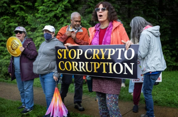 Des manifestants devant le Trump National Golf Course à Sterling, en Virginie, le 22 mai 2025, où le président Donald Trump participe à un dîner privé dans son club pour les 220 plus gros détenteurs de sa cryptomonnaie