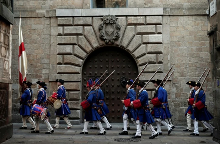 Des participants vêtus d'uniformes militaires d'époque prennent part à une reconstitution historique à Barcelone le 11 septembre 2018 pour la "Diada", "fête nationale" catalane commémorant la prise de la ville en 1714 par les troupes du roi Felipe V