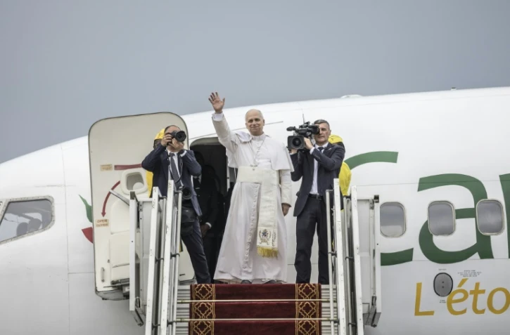 Le pape Léon XIV (au centre) salue ses fidèles alors qu'il monte à bord d'un avion, après avoir célébré la sainte messe à l'aéroport de Bamenda, au Cameroun, le 16 avril 2026