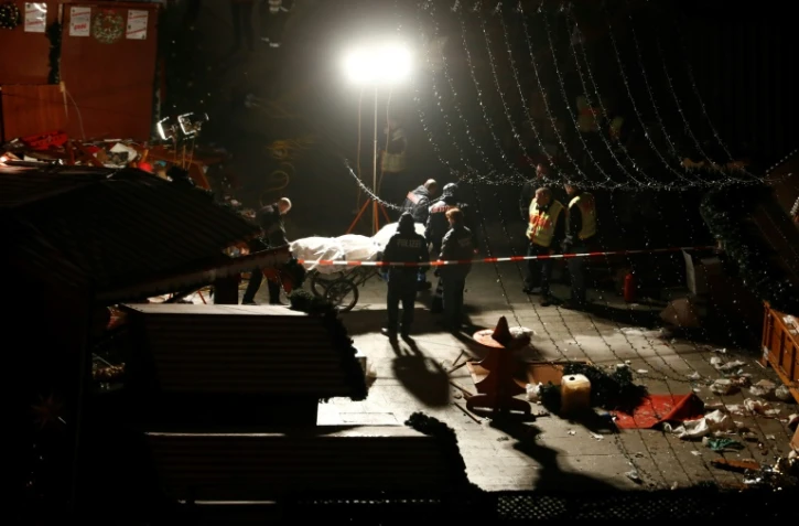 Les secours évacuent des corps sur les lieux où un camion a roulé dans la foule à un marché de Noël à Berlin le 19 décembre 2016