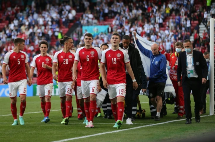 Les joueurs danois escortent l'équipe médicale qui évacue sur une civière Christian Eriksen après son malaise cardiaque contre la Finlande le 12 juin 2021 à Copenhague