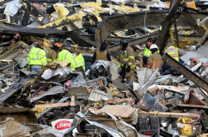 Des secouristes à pied d'oeuvre samedi 11 décembre 2021 dans une usine de bougies de Mayfield