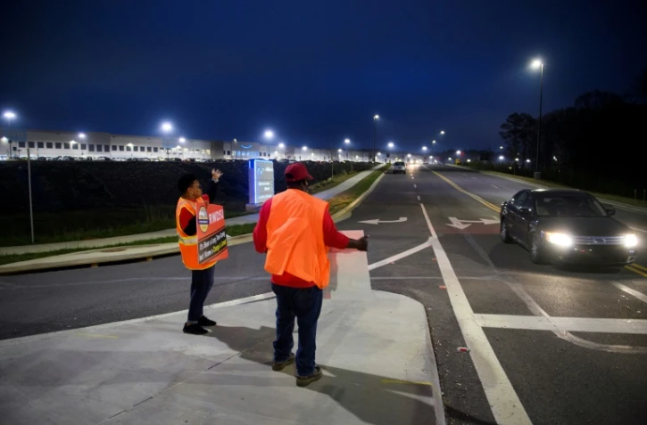 Les syndicalistes Syrena et Steve saluent les employés d'Amazon à l'entrée de l'entrepôt de Bessemer, dans l'Alabama, (Etats-Unis) le 27 mars 2021