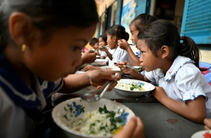 Des écoliers prennent un petit-déjeuner avant d'entrer en classe, le 8 juillet 2022 dans la province de Siem Reap, au Cambodge