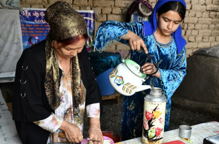 Iodgoroï Makhmalieva (g) et sa petite-fille Mounissa, déplacées climatiques, dans leur nouvelle maison du district de Khourosson, le 26 mars 2024 au Tadjikistan