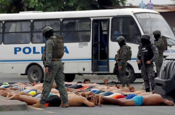 Des policiers surveillent des personnes interpellées après une tentative d'assaut dans un hôpital à Guayas, le 21 janvier 2024 en Equateur