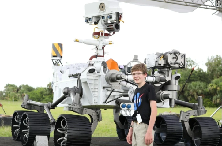 Alex Mather, 13 ans, qui a proposé le nom de Perseverance à la Nasa, pose à côté d'une maquette grandeur nature du rover, le 28 juillet 2020 à Cap Canaveral, en Floride