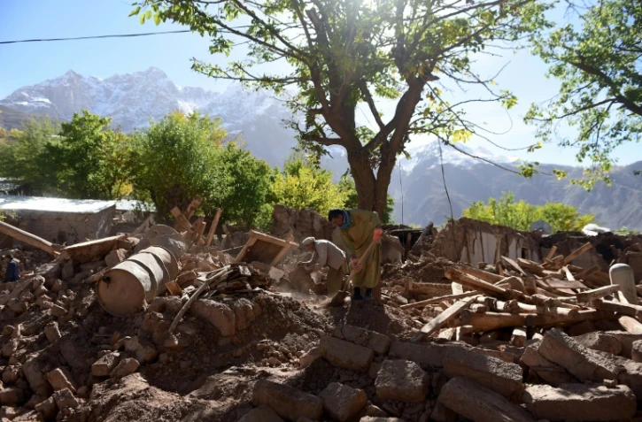 Des survivants au milieu des ruines le 29 octobre 2015 dans le village de Charun Avir au Pakistan