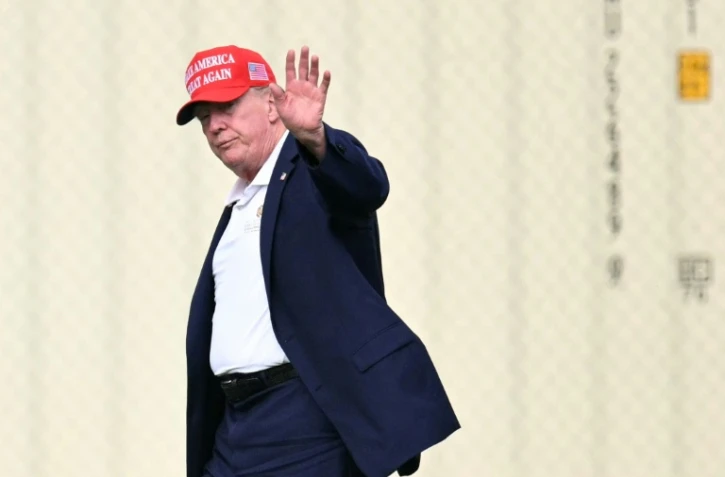 Le président Donald Trump salue en direction de la presse à son arrivée à la Maison Blanche, à Washington, le 16 août 2026