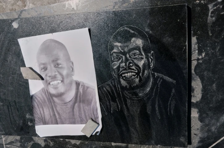 Portrait d'un défunt gravé par Denzel Karombe (ne figurant pas sur la photo), 19 ans, qui travaille dans une entreprise funéraire spécialisée à Rugare (Zimbabwe), en banlieue de Harare, le 21 avril 2023